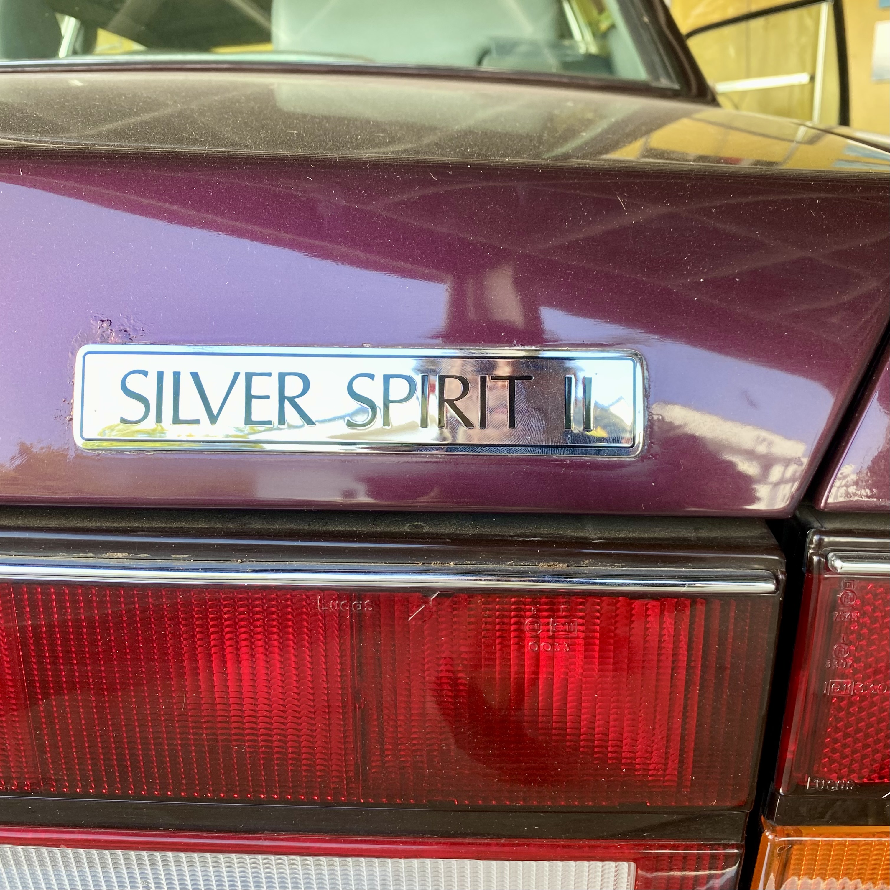 Close-up of the rear badge of a silver car, displaying the text 'SILVER SPIRIT II'.
