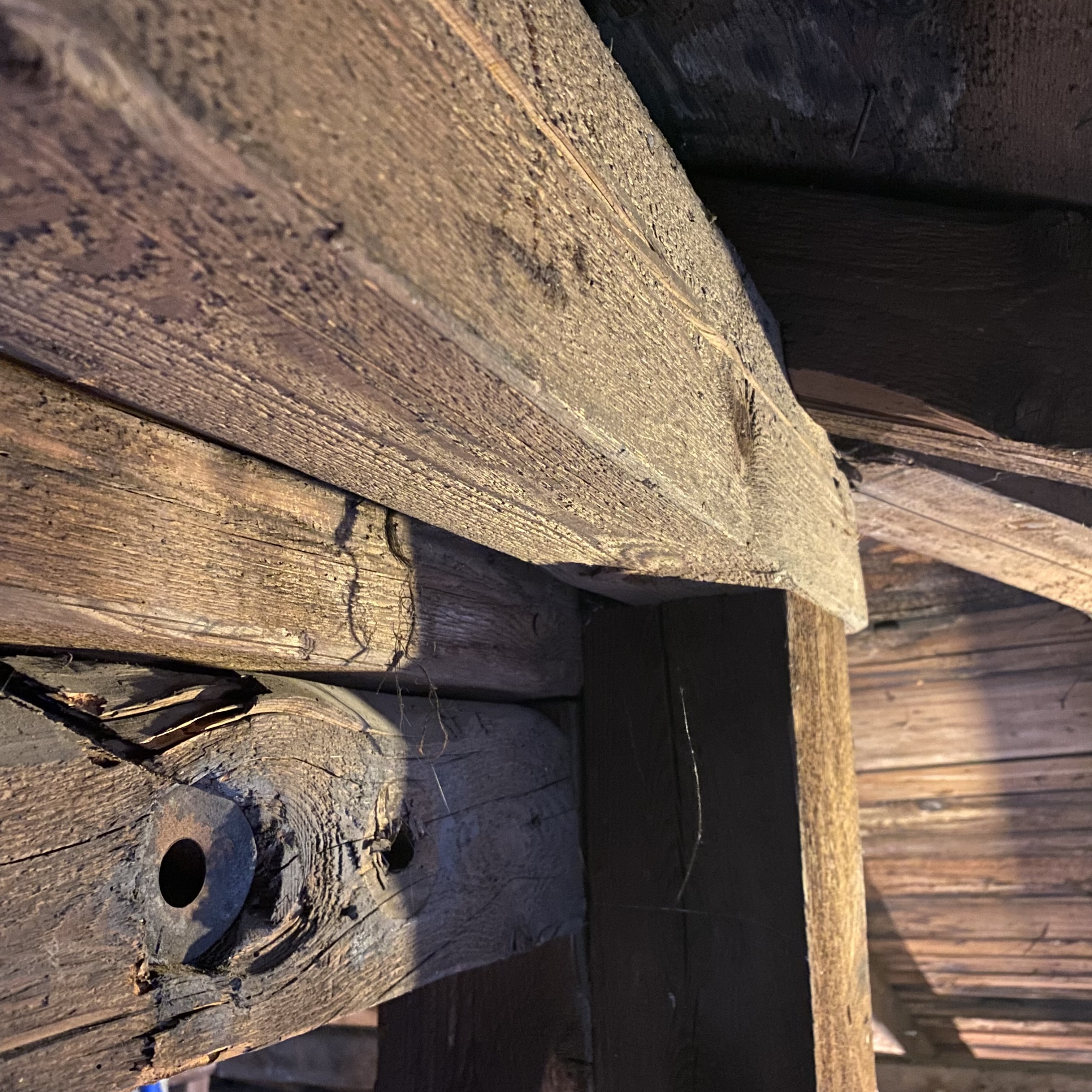 Close-up view of weathered wooden beams and structural elements with visible textures and imperfections.