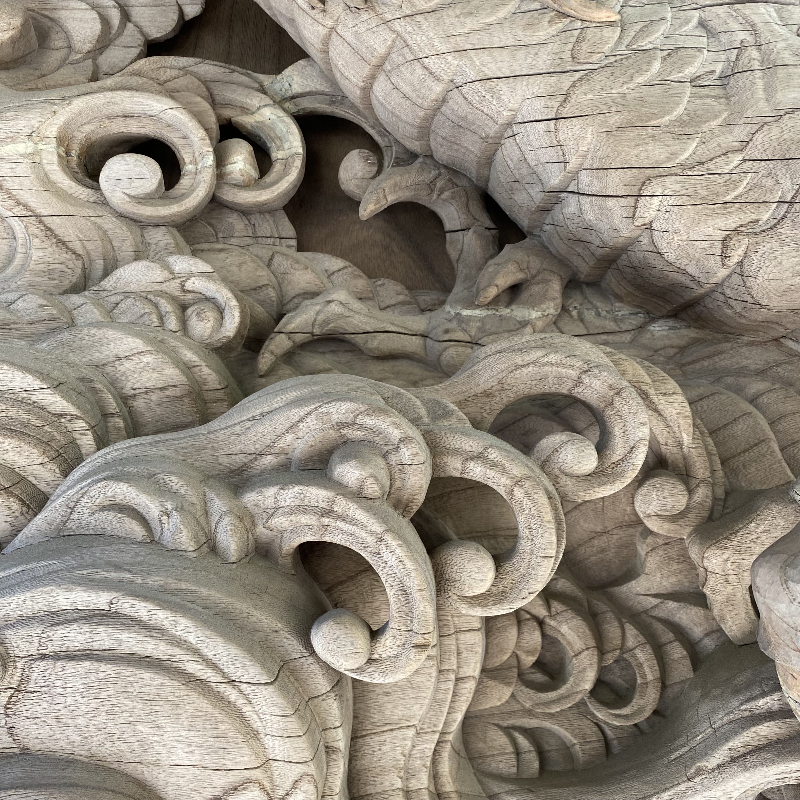 Intricate wood carving featuring swirling patterns and detailed shapes.